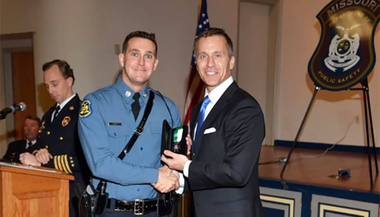 Staff Sgt Austin Kings and a member of the Highway Patrol receives Medal of Merit