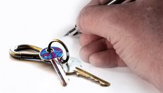 House keys and hand with pen