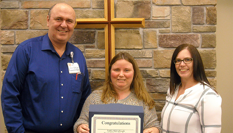 Tabby McCullough receives the Wright Memorial Hospital Employee of the Quarter Award for first quarter 2018 from Gary Jordan, CEO, and Mandy Willey, Supervisor, Patient Access.