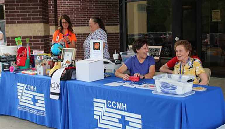 CCMH staff and Auxiliary volunteers stationed at the check-in table of the Health Fair & Family Fun Night.