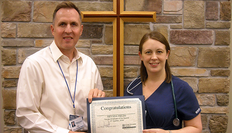 Nevada Fields (right) receives the Wright Memorial Hospital Employee of the Quarter Award for third quarter 2018 from Steve Schieber (left), CEO