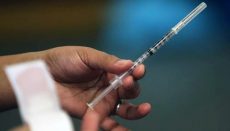 Hand holding hypodermic needle