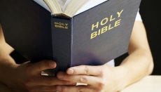 Person holding Holy Bible