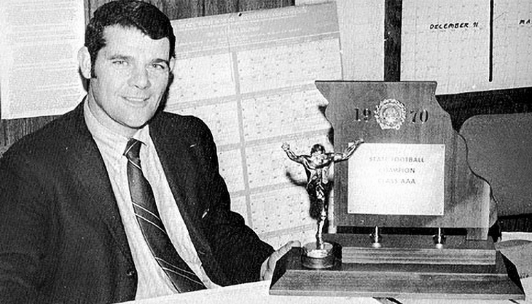 Bob Fairchild posing with 1970 State Football Championship Trophy
