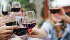 People holding glasses of wine (Photo by Kelsey Knight on Unsplash)