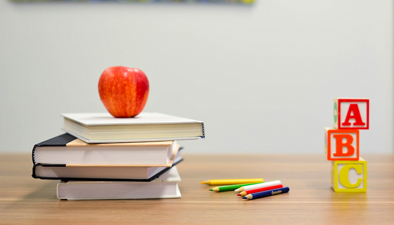 School or education or apple on books with colored pencl and childrens blocks