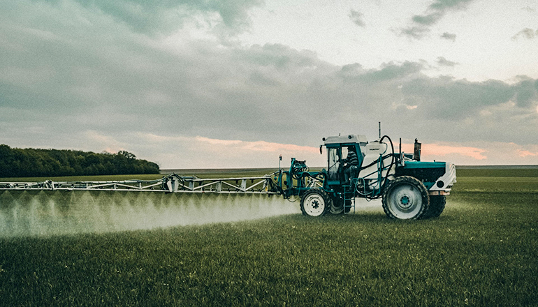 Farmer spraying with a tractor in a field