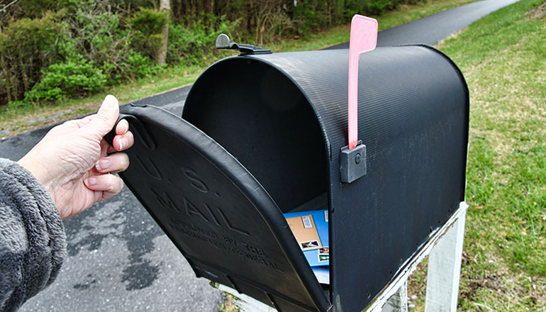 Person mail a letter in a rural mailbox or postal carrier delivering rural mail