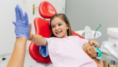 Little girl (child) sitting on dental chair and having dental treatment