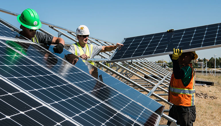 Construction workers installing solar panels