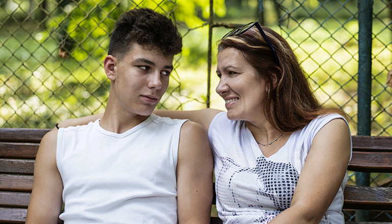 A middle-aged woman is good spending time with her son in a park
