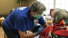 Regina Murdock, a registered nurse with D&H Drugstore, administers a dose of the Pfizer vaccine to a resident on Aug. 6, 2021