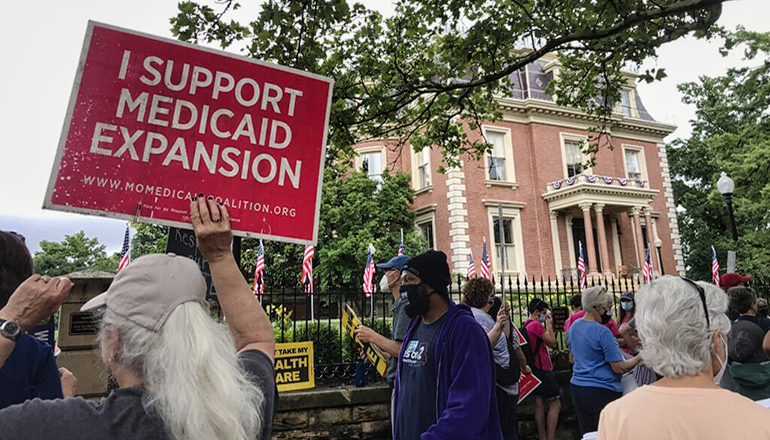 Demonstrators stand outside of the Governor’s Mansion in Jefferson City (Photo by Tessa Weinberg - Missouri Independent).