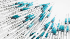 Syringes on table (Photo by Jeremy Bezanger on Unsplash)