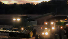 Combine and farm tractor with wagon in field