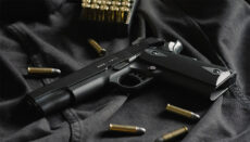 Photo of handgun and ammunition (Photo by Thomas Def on Unsplash)
