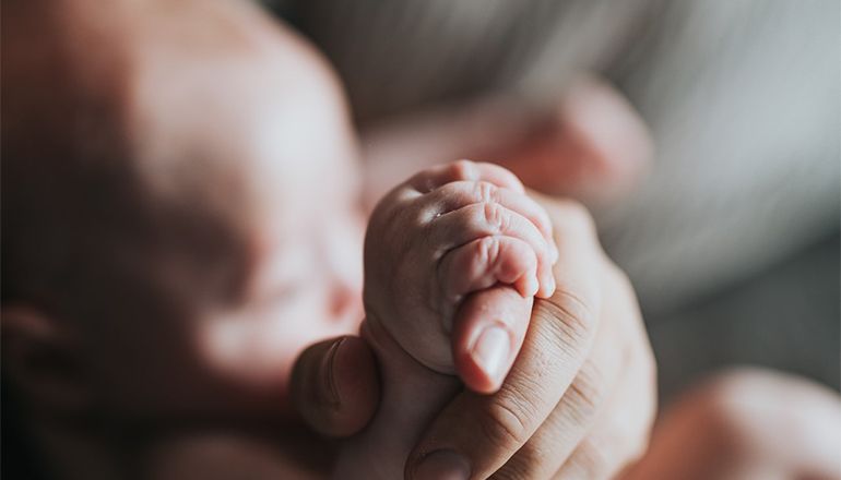 Hands of baby and mother (Photo by Nathan Dumlao on Unsplash)