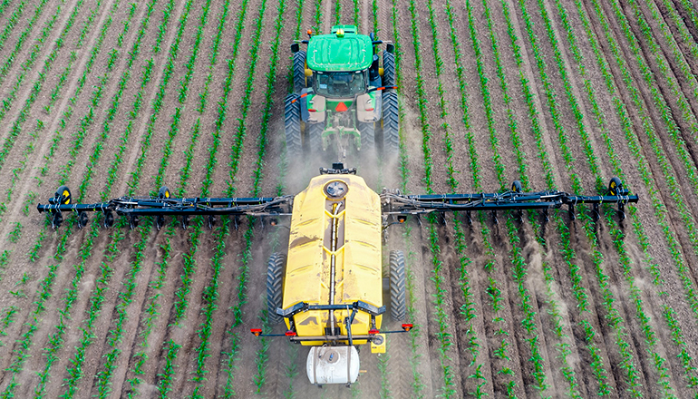 Farm tractor applying fertilizer (Photo by James Baltz on Unsplash)