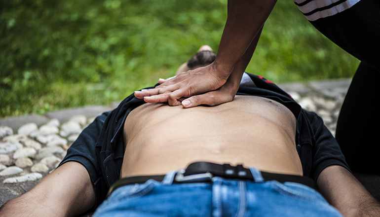 Woman giving CPR to man or victim on the ground (Photo via Envato Elements)