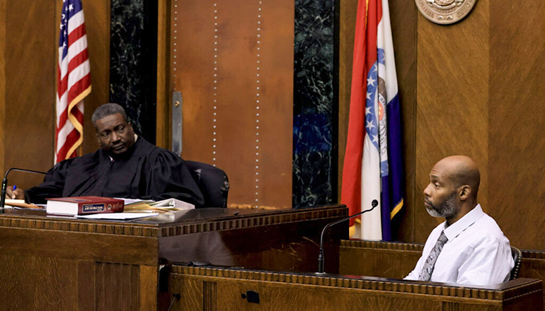 Lamar Johnson testifies on the stand during the fourth day of his wrongful conviction hearing in St. Louis on Thursday, Dec. 15, 2022. Circuit Court Judge David Mason is pictured to the left. Photo by David Carson, dcarson@post-dispatch.com