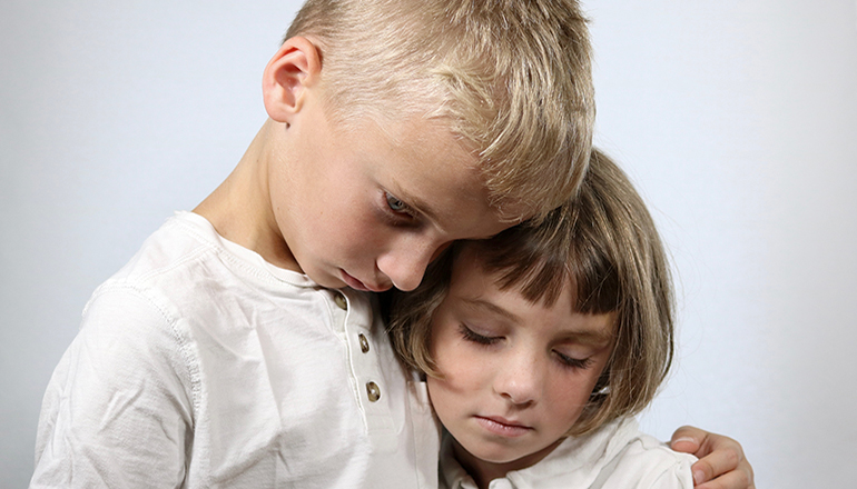 Unhappy Children offering comfort to each other (Photo via Adobe Stock Images)