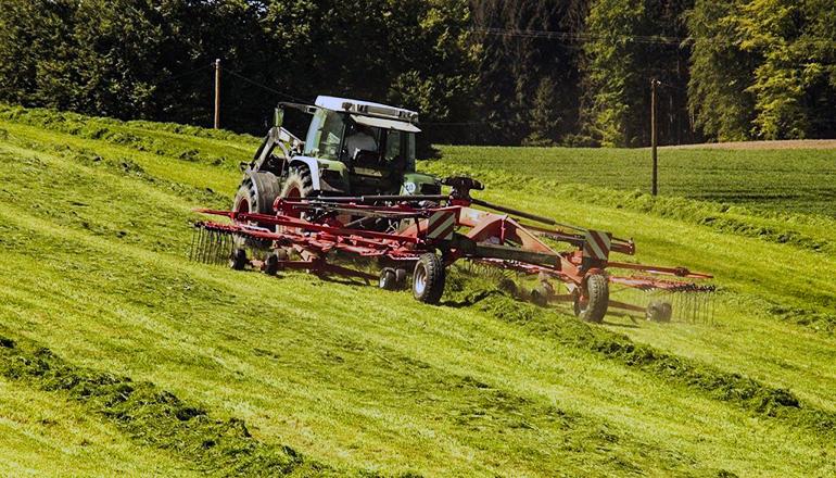 Farmer cutting hay io a field (Photo via Adobe Stock Images)