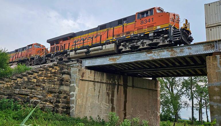 A Burlington Northern freight train on Aug. 4, 2023, crosses a bridge (Photo by Rude Keller - Missouri Independent)