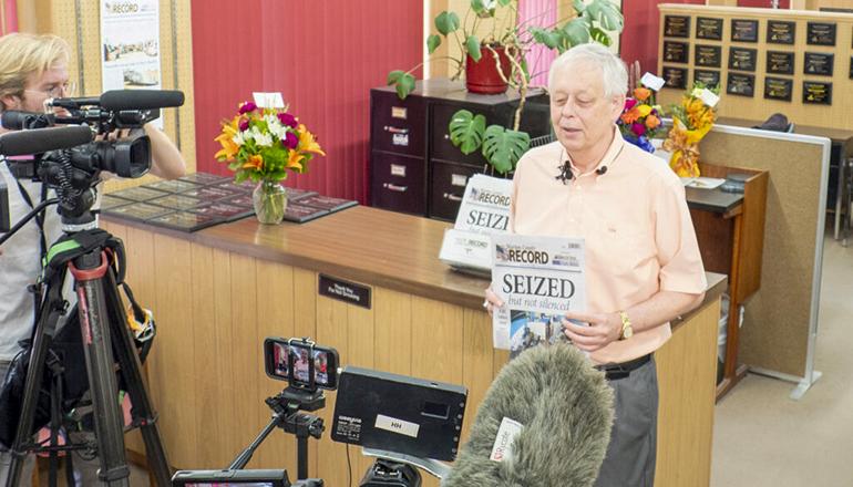 Marion County Record publisher Eric Meyer holds a copy of the Wednesday paper (Photo by Sherman Smith - Kansas Reflector)