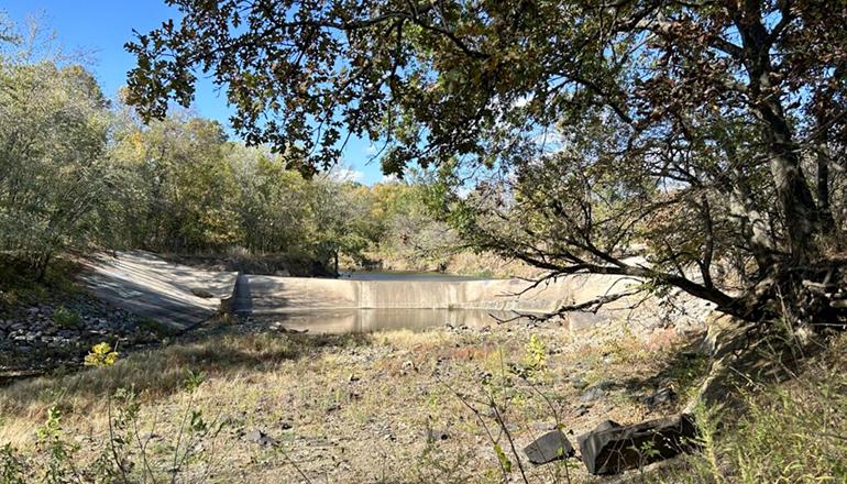 Water levels in the Little Caney River in southeast Kansas are so low that the river isn’t flowing over the dam, leaving the stream dry (Photo by Allison Kite - Kansas Reflector).