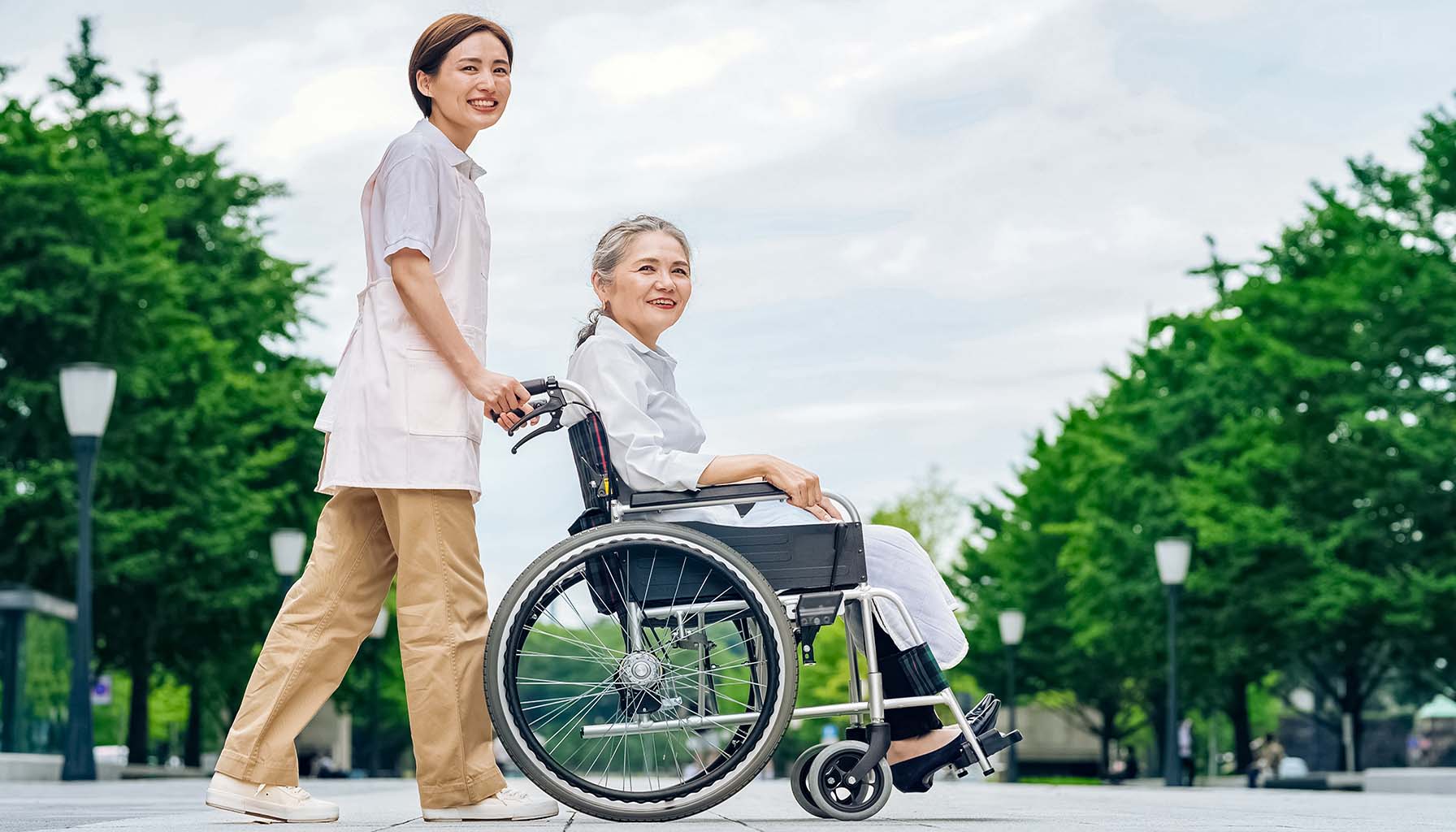 (Nursing home patient in a wheelchair and employee. Photo credit Getty Images, licensed through Unsplash +)